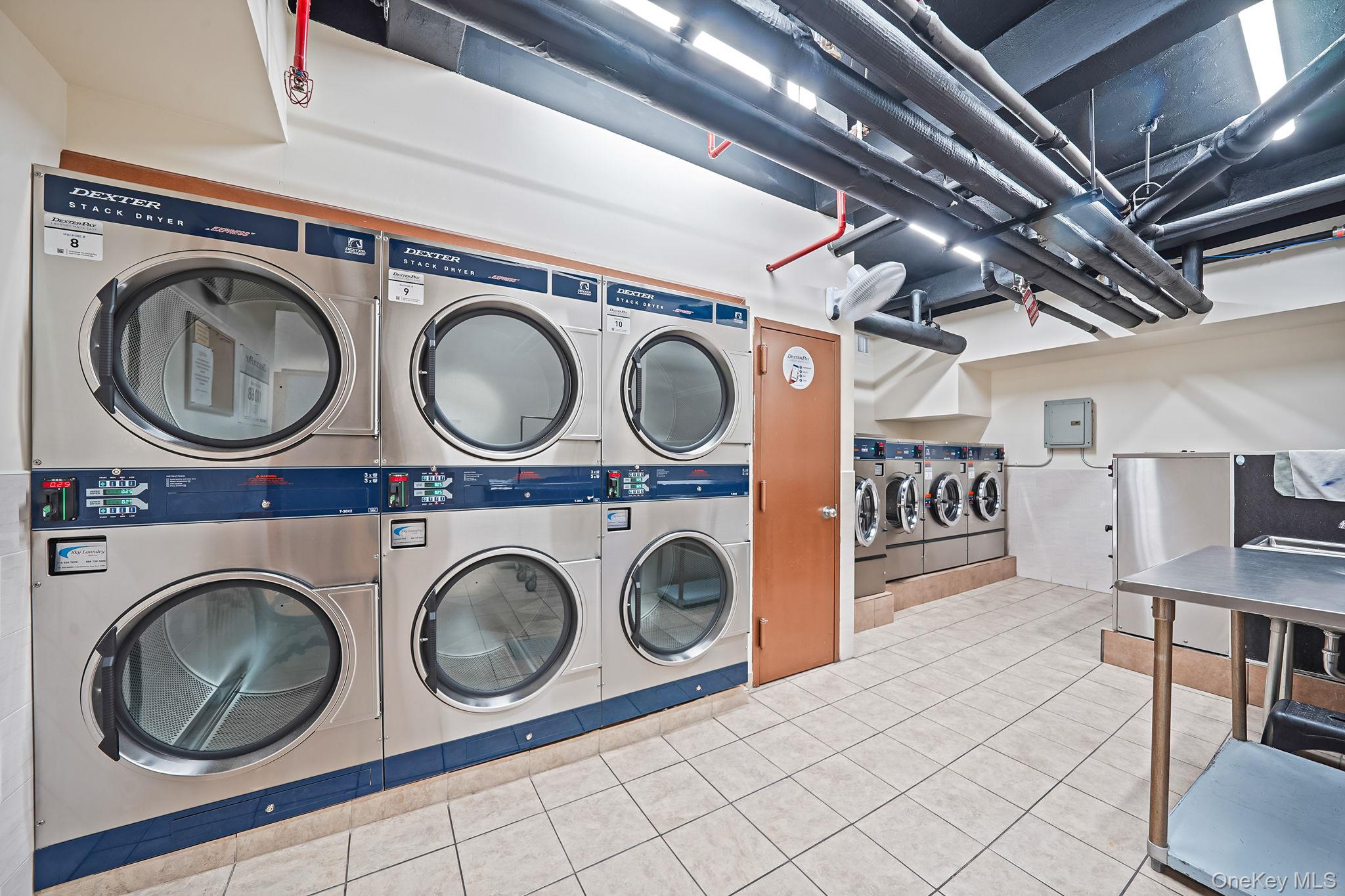 67-50 Thornton Place, Unit 4U Queens, NY 11375 - Photo 14 of 19 Shared laundry room with tile patterned flooring, washing machine and clothes dryer, electric panel, and stacked washer and clothes dryer