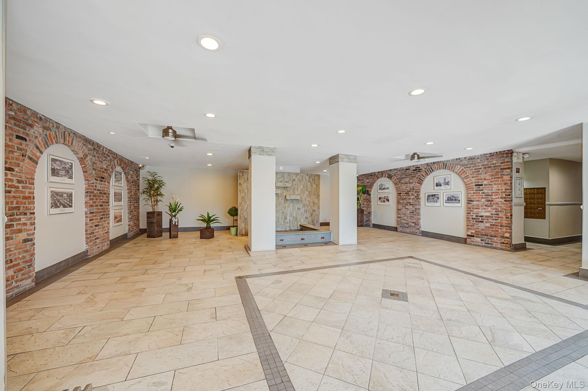 67-50 Thornton Place, Unit 4U Queens, NY 11375 - Photo 16 of 19 Common area with brick wall and recessed lighting