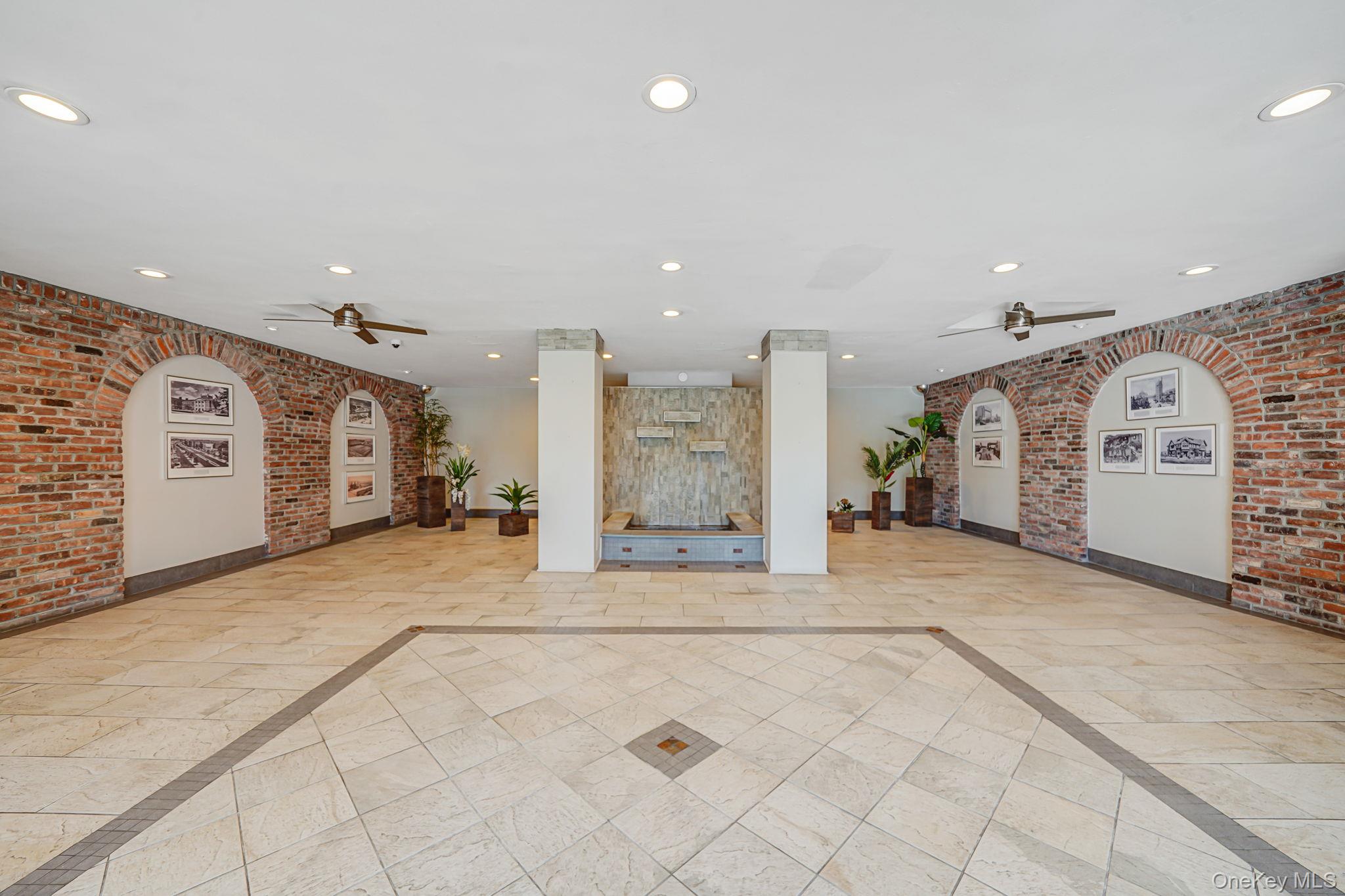 67-50 Thornton Place, Unit 4U Queens, NY 11375 - Photo 3 of 19 Common area with brick wall and recessed lighting