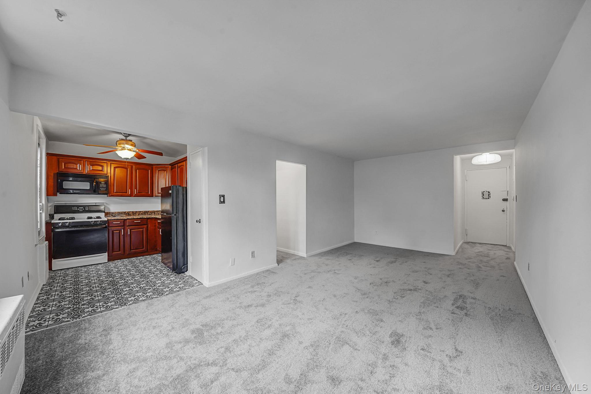 67-50 Thornton Place, Unit 4U Queens, NY 11375 - Photo 6 of 19 Unfurnished living room with light carpet and baseboards