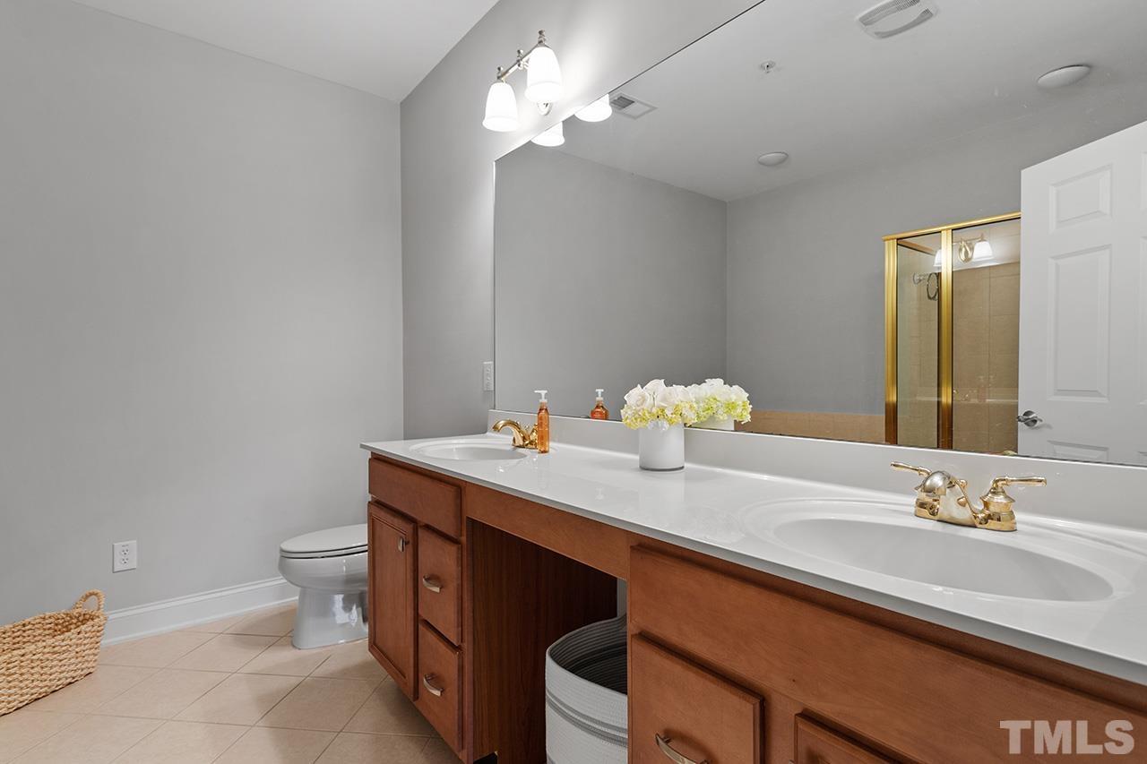 10421 Rosegate Court, Unit 5 Raleigh, NC 27617 - Photo 27 of 35 a bathroom with a sink a toilet and a mirror