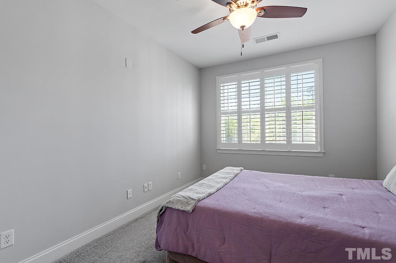 10421 Rosegate Court, Unit 5 Raleigh, NC 27617 - Photo 30 of 35 a bedroom with a bed and a chandelier