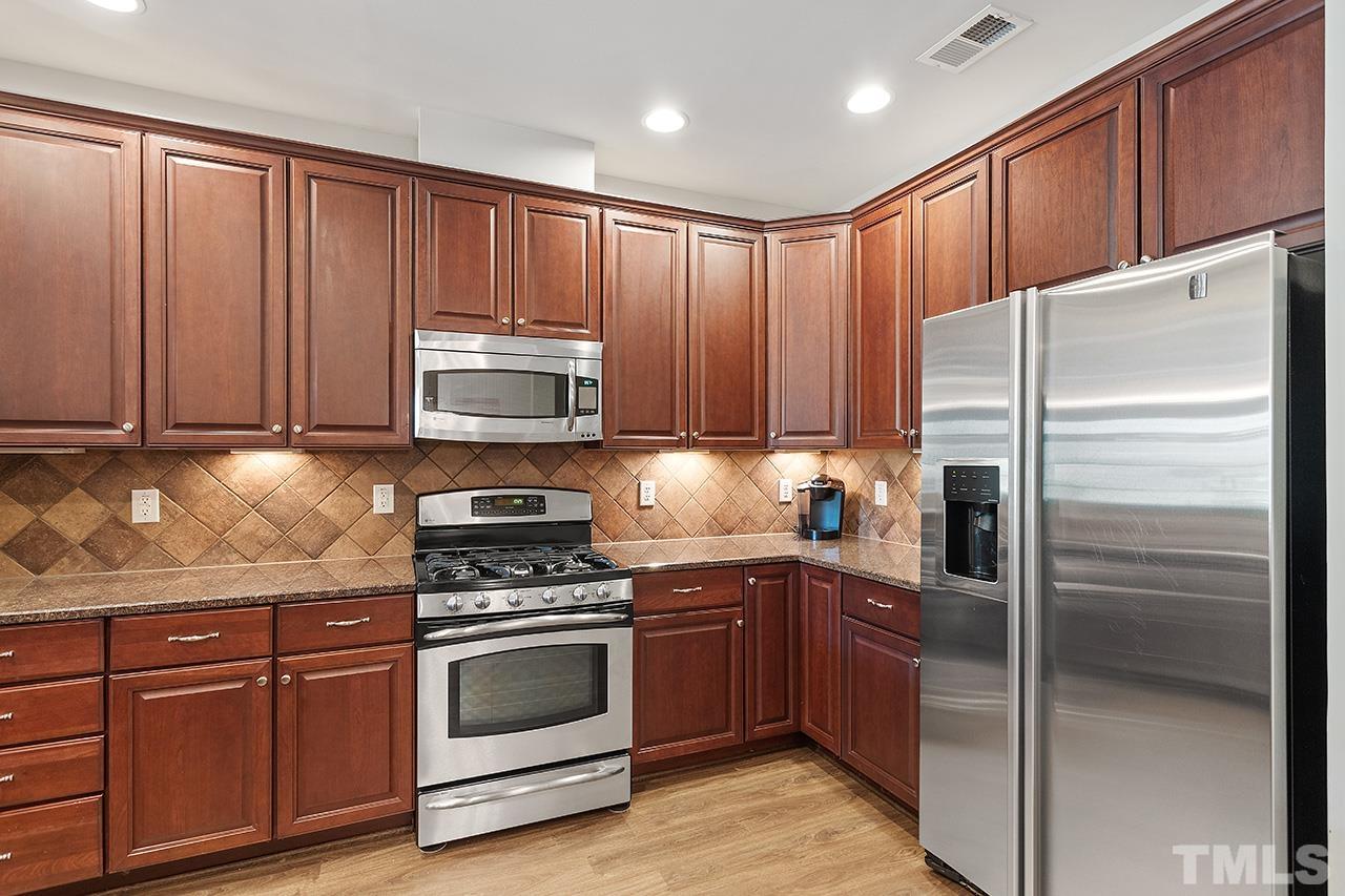 10421 Rosegate Court, Unit 5 Raleigh, NC 27617 - Photo 8 of 35 a kitchen with granite countertop wooden cabinets and stainless steel appliances