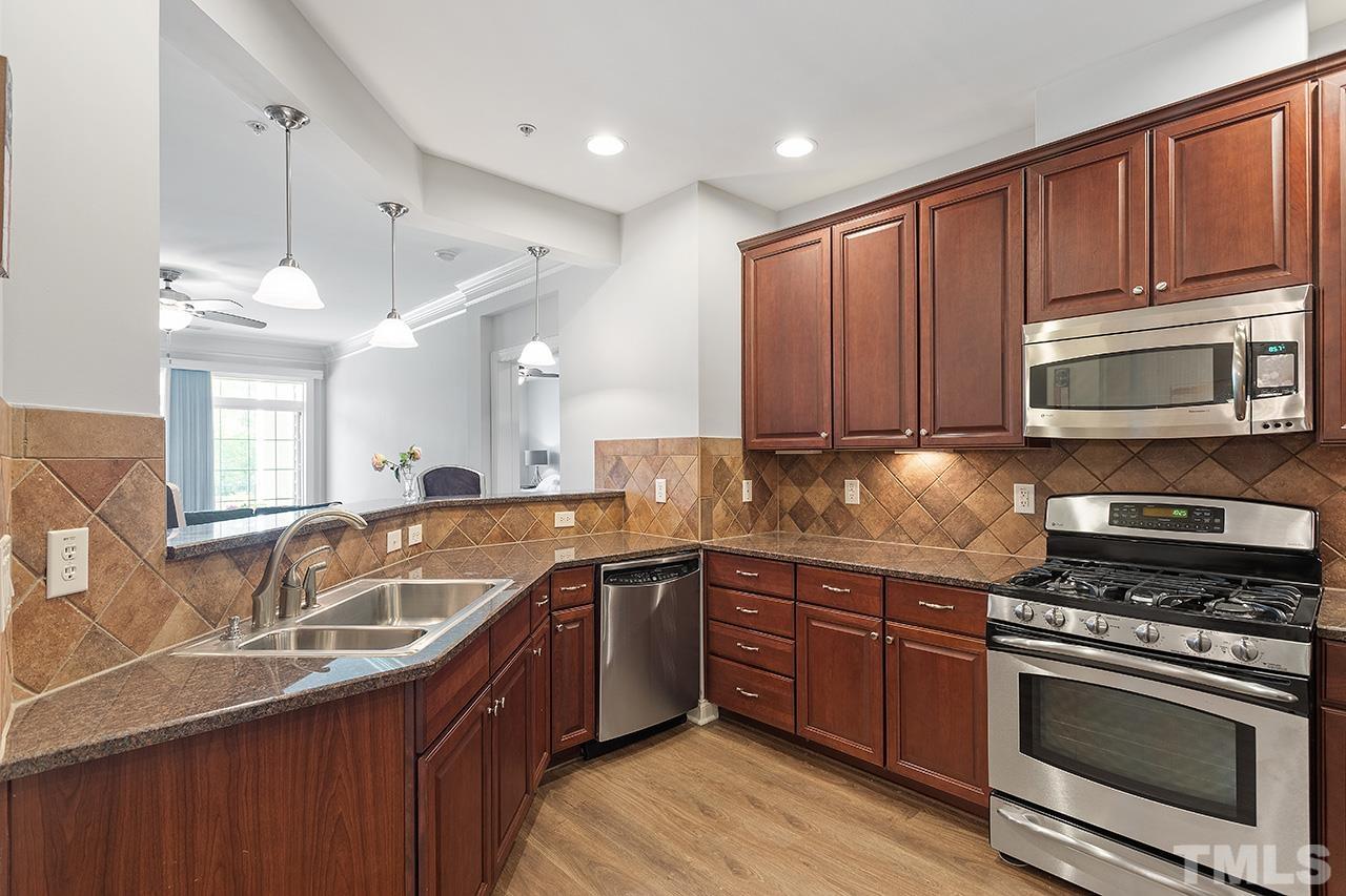 10421 Rosegate Court, Unit 5 Raleigh, NC 27617 - Photo 10 of 35 a kitchen with stainless steel appliances granite countertop a sink stove and microwave