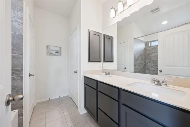 a bathroom with a double vanity sink a mirror and a shower