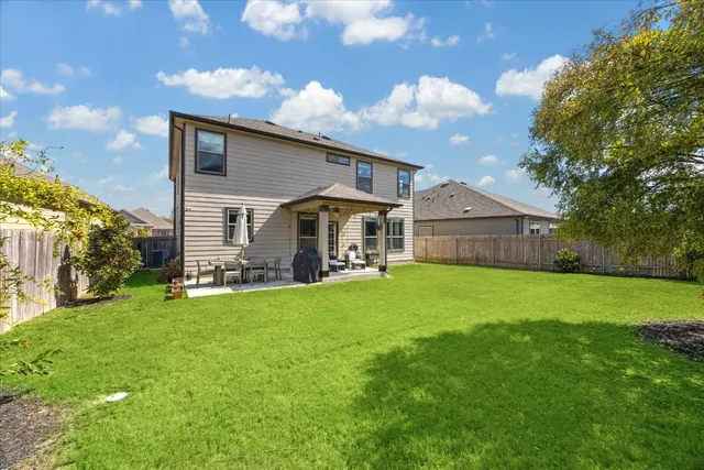 a front view of house with yard barbeque and outdoor seating