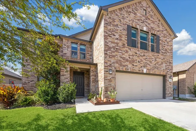 a front view of a house with a yard and garage