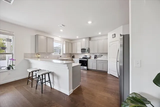 a kitchen with a sink and chairs