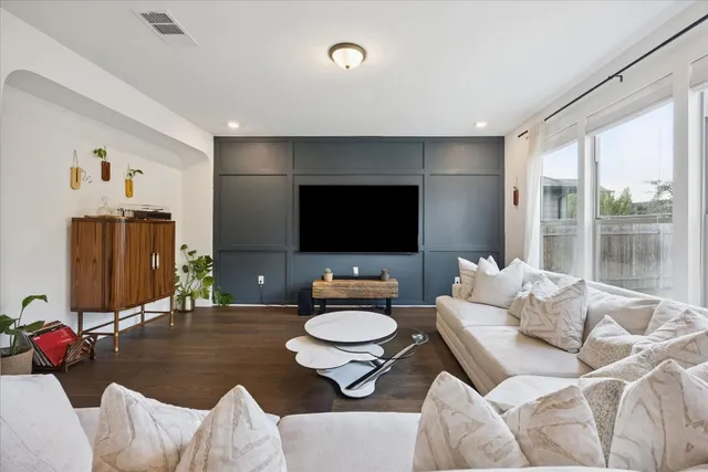 a living room with furniture a flat screen tv and a large window