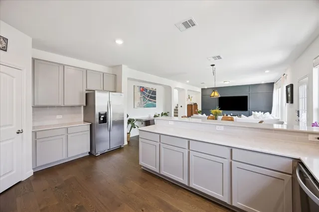 a kitchen with stainless steel appliances a refrigerator sink and white cabinets