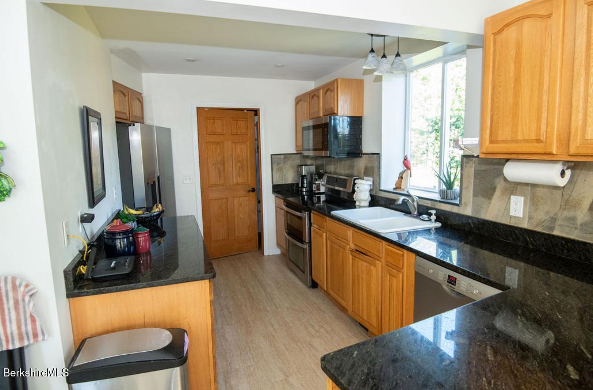 107 Wilderness Way Stephentown, NY 12169 - Photo 11 of 33 a kitchen with stainless steel appliances granite countertop a sink a stove and a refrigerator