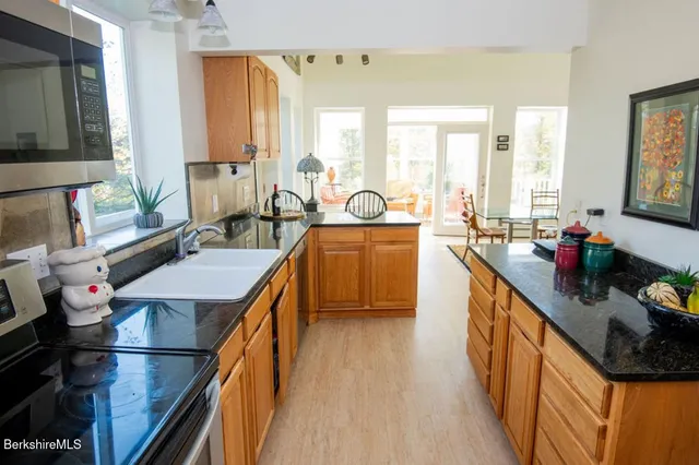 a kitchen with stainless steel appliances granite countertop sink stove and cabinets