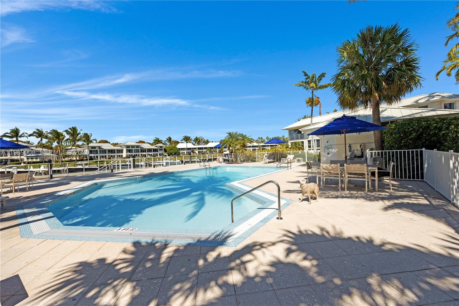26 Marlin Lane, Unit B Key Largo, FL 33037 - Photo 12 of 16 a view of a swimming pool with lawn chairs under an umbrella