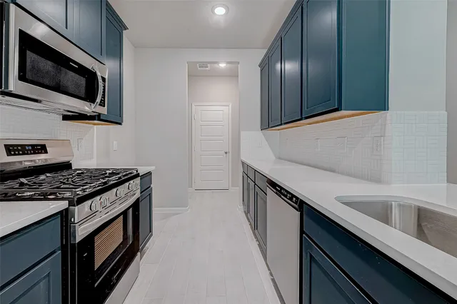 a kitchen with stainless steel appliances granite countertop a sink and a stove top oven