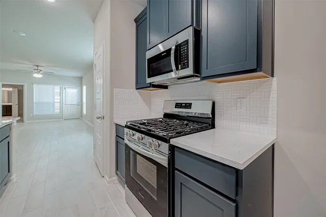 a kitchen with stainless steel appliances granite countertop a stove and a microwave
