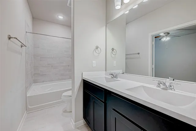 a bathroom with a double vanity sink mirror and refrigerator