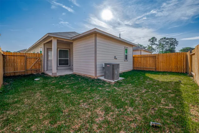 a backyard of a house with plants and wooden fence