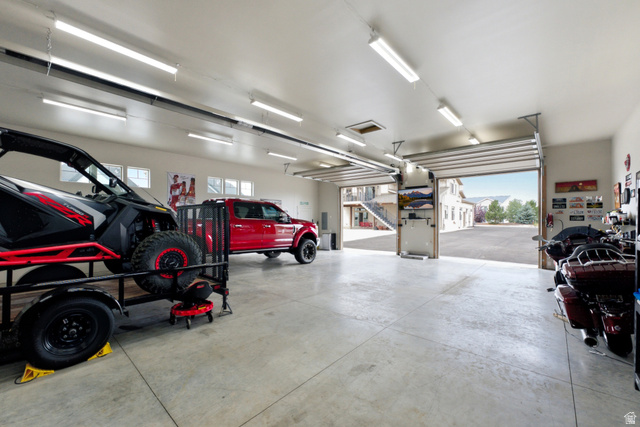 560 Aspen Road Francis, UT 84036 - Photo 15 of 59 Spacious garage with multiple overhead doors, concrete flooring, and ample overhead lighting