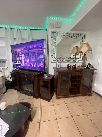 a living room with furniture a flat screen tv and kitchen view