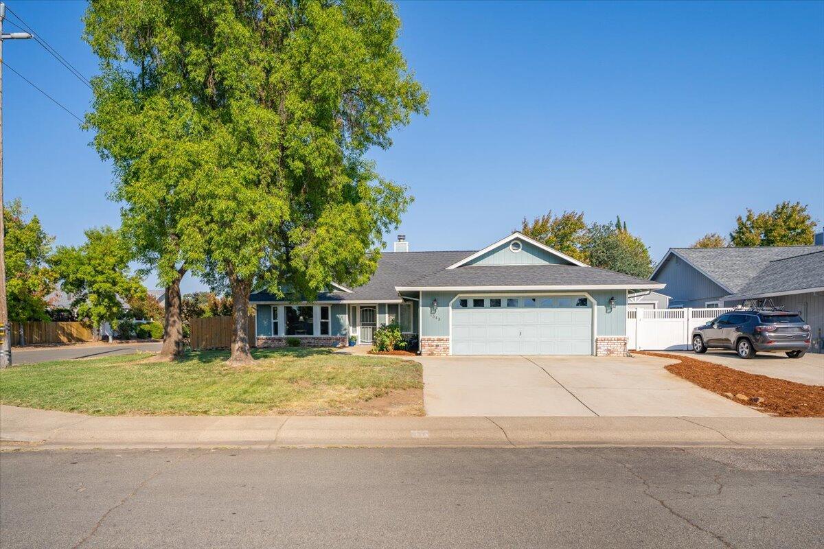 1543 Marigold Way Redding, CA 96003 - Photo 37 of 47 a front view of a house with a garden and trees
