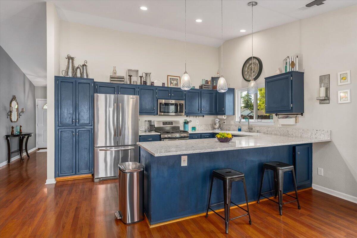 1543 Marigold Way Redding, CA 96003 - Photo 6 of 47 a kitchen with stainless steel appliances a dining table chairs stove and refrigerator