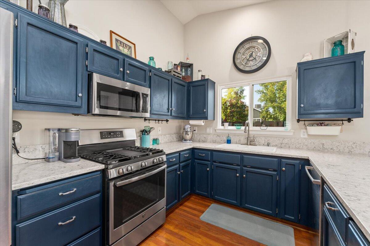 1543 Marigold Way Redding, CA 96003 - Photo 7 of 47 a kitchen with stainless steel appliances granite countertop wooden cabinets a stove top oven and a sink