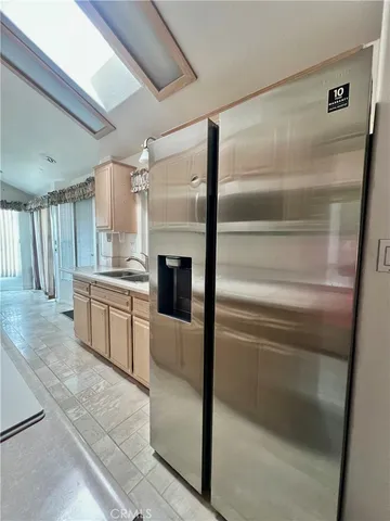 a kitchen with a refrigerator and white cabinets