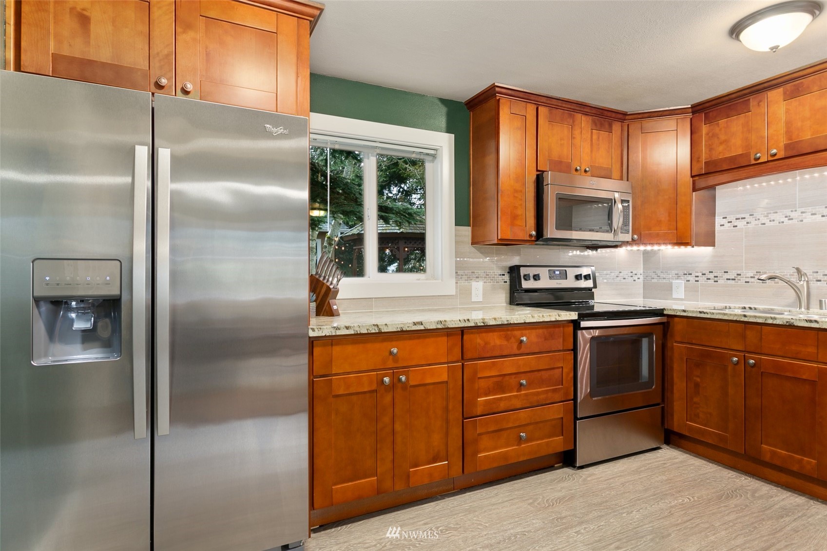 3523 Northeast 6th Street Renton, WA 98056 - Photo 8 of 27 a kitchen with stainless steel appliances granite countertop a refrigerator a stove a sink and a window