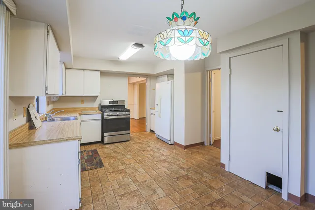 a kitchen with a refrigerator a stove and a sink