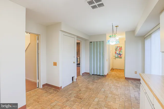 an empty room with kitchen view and window
