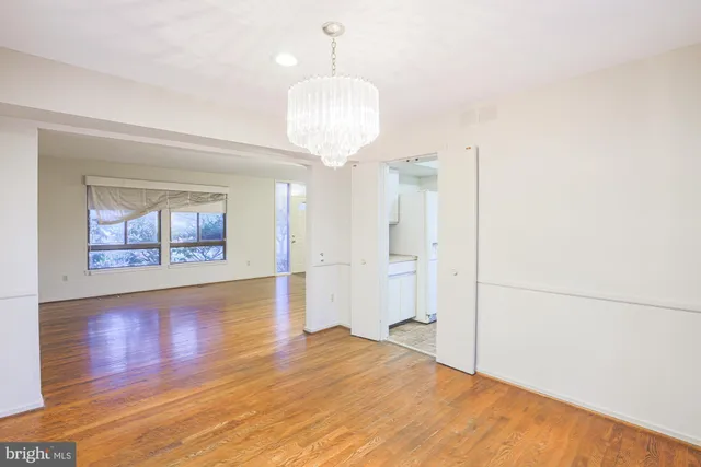 a view of a room with wooden floor and chandelier