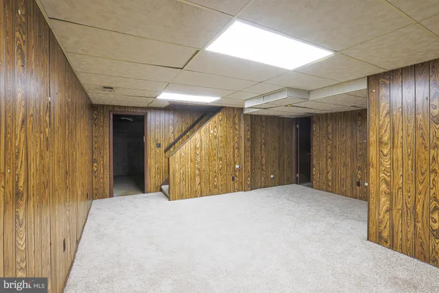 an empty room with windows and chandelier fan