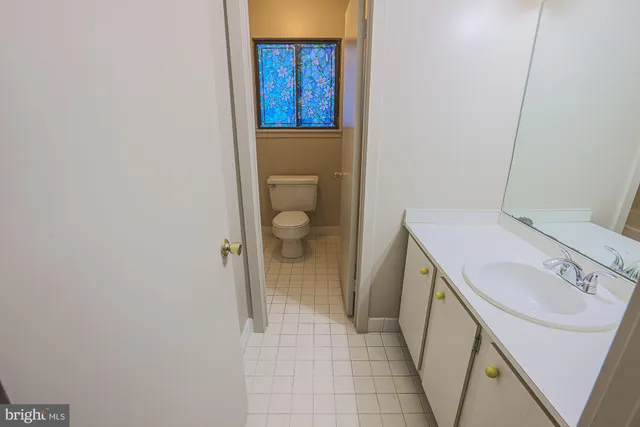 a bathroom with a granite countertop toilet sink and mirror