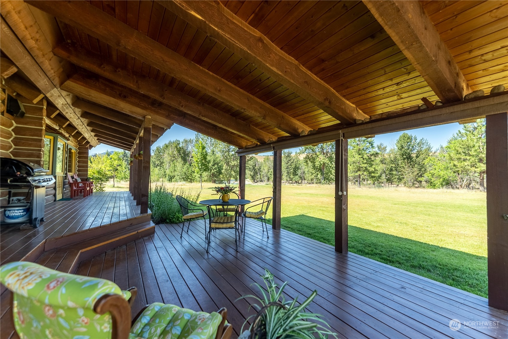 16 Lewisia Road Winthrop, WA 98862 - Photo 19 of 40 a view of a patio with table and chairs potted plants with wooden floor