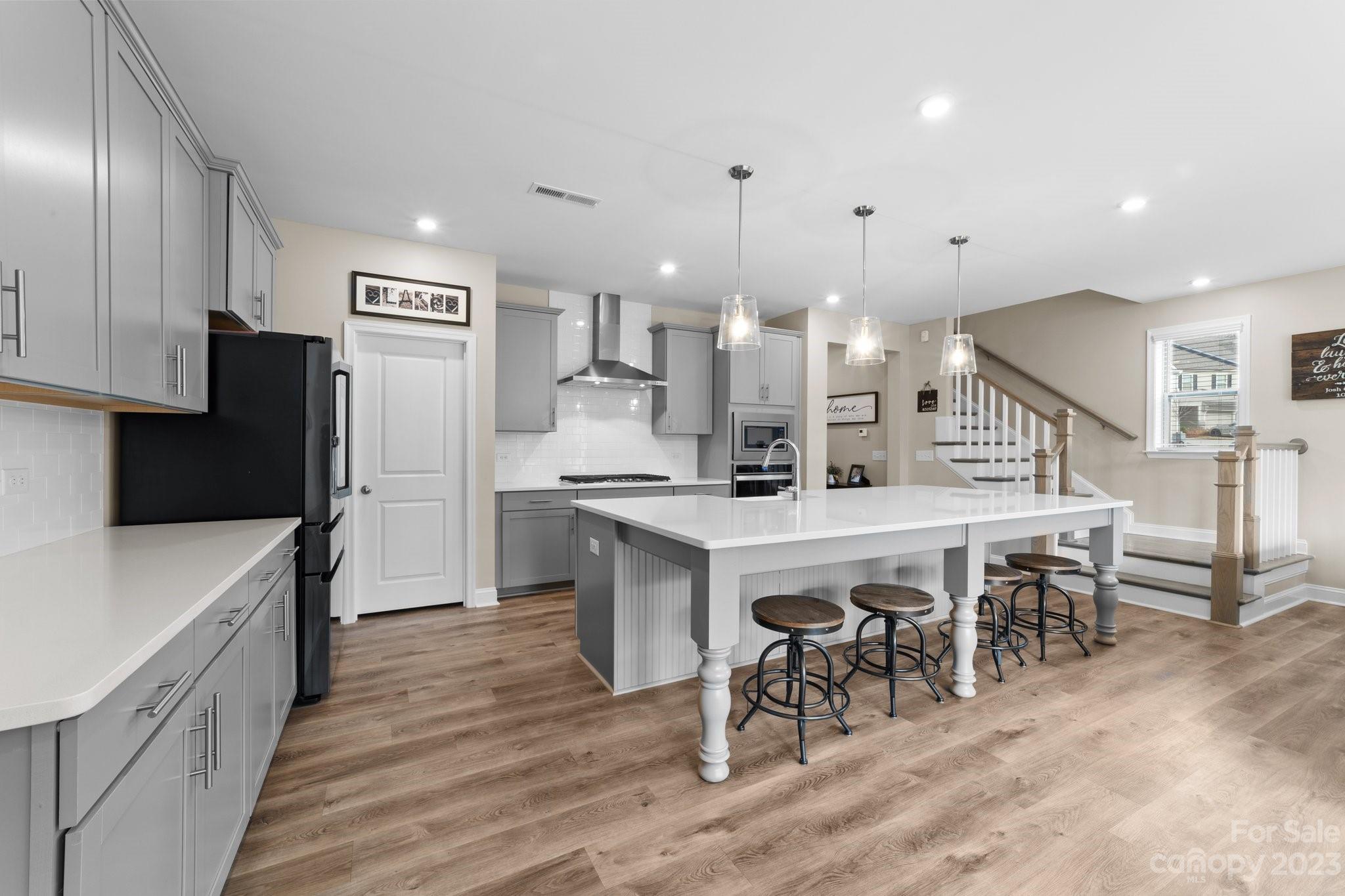 2041 Suttonview Road Fort Mill, SC 29708 - Photo 9 of 27 a kitchen with stainless steel appliances a table chairs refrigerator and cabinets