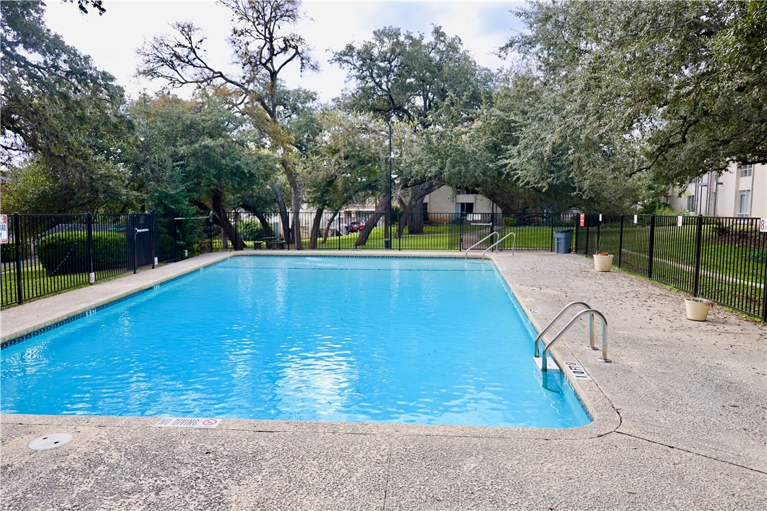a view of swimming pool with deck and trees