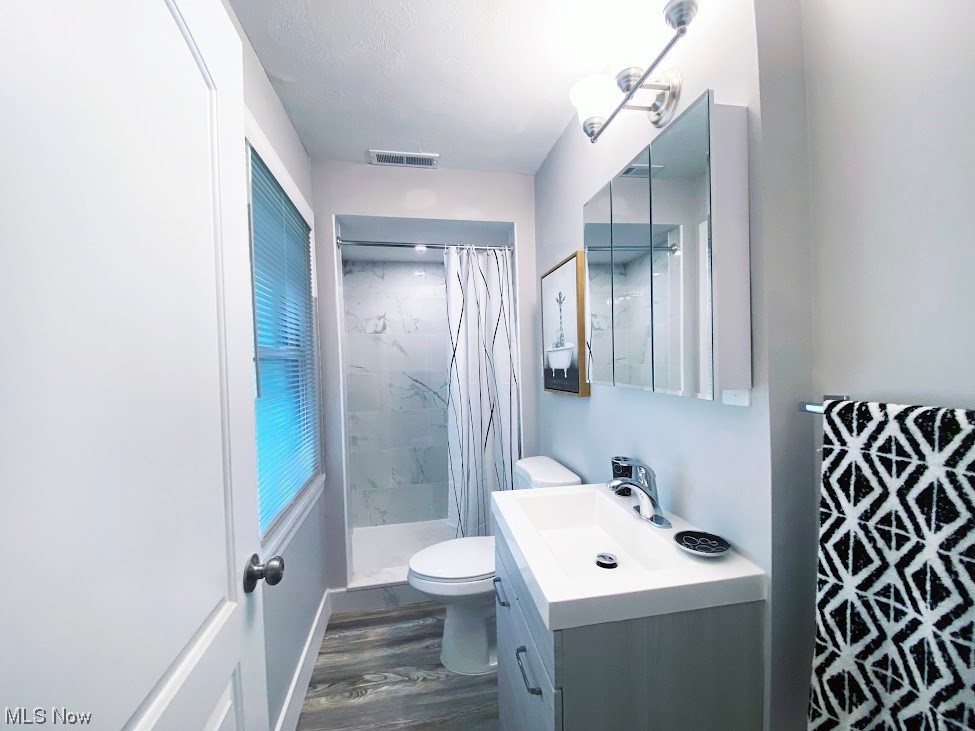 2140 Reyburn Road Cleveland, OH 44112 - Photo 14 of 18 Bathroom with large vanity, toilet, hardwood / wood-style flooring, and walk in shower