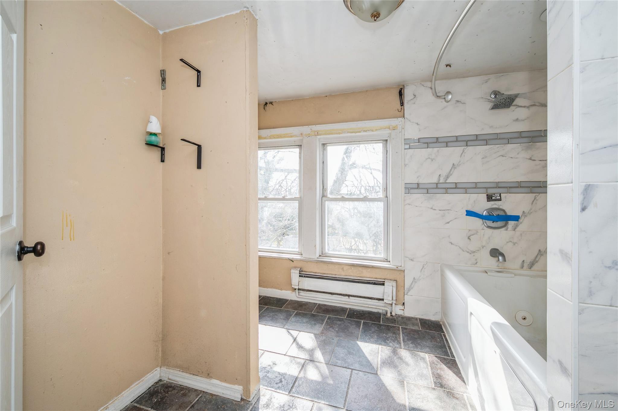 5 Church Street Baldwin, NY 11510 - Photo 18 of 32 a bathroom with a bathtub and a shower