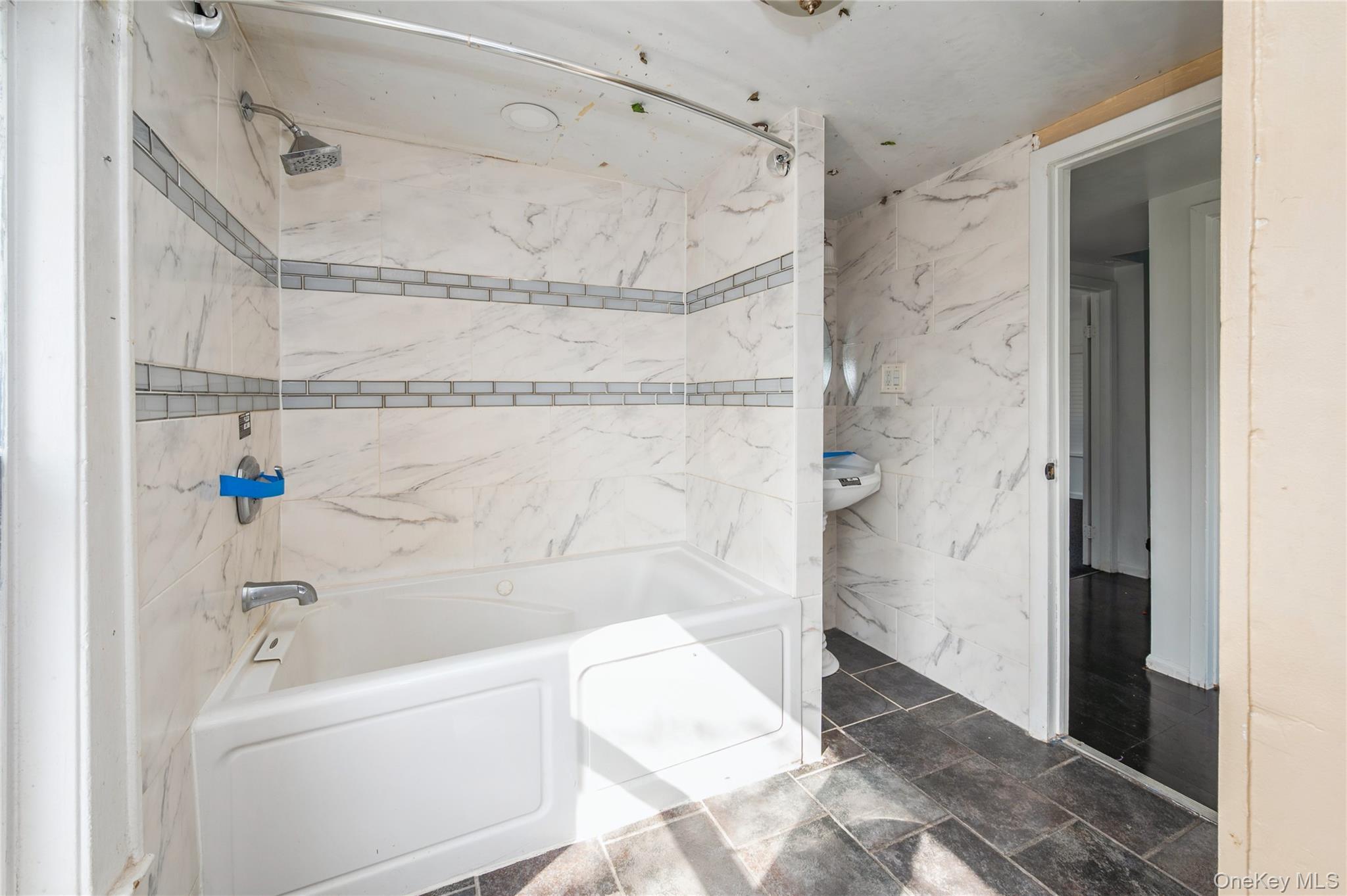 5 Church Street Baldwin, NY 11510 - Photo 19 of 32 a bathroom with a bathtub and a shower
