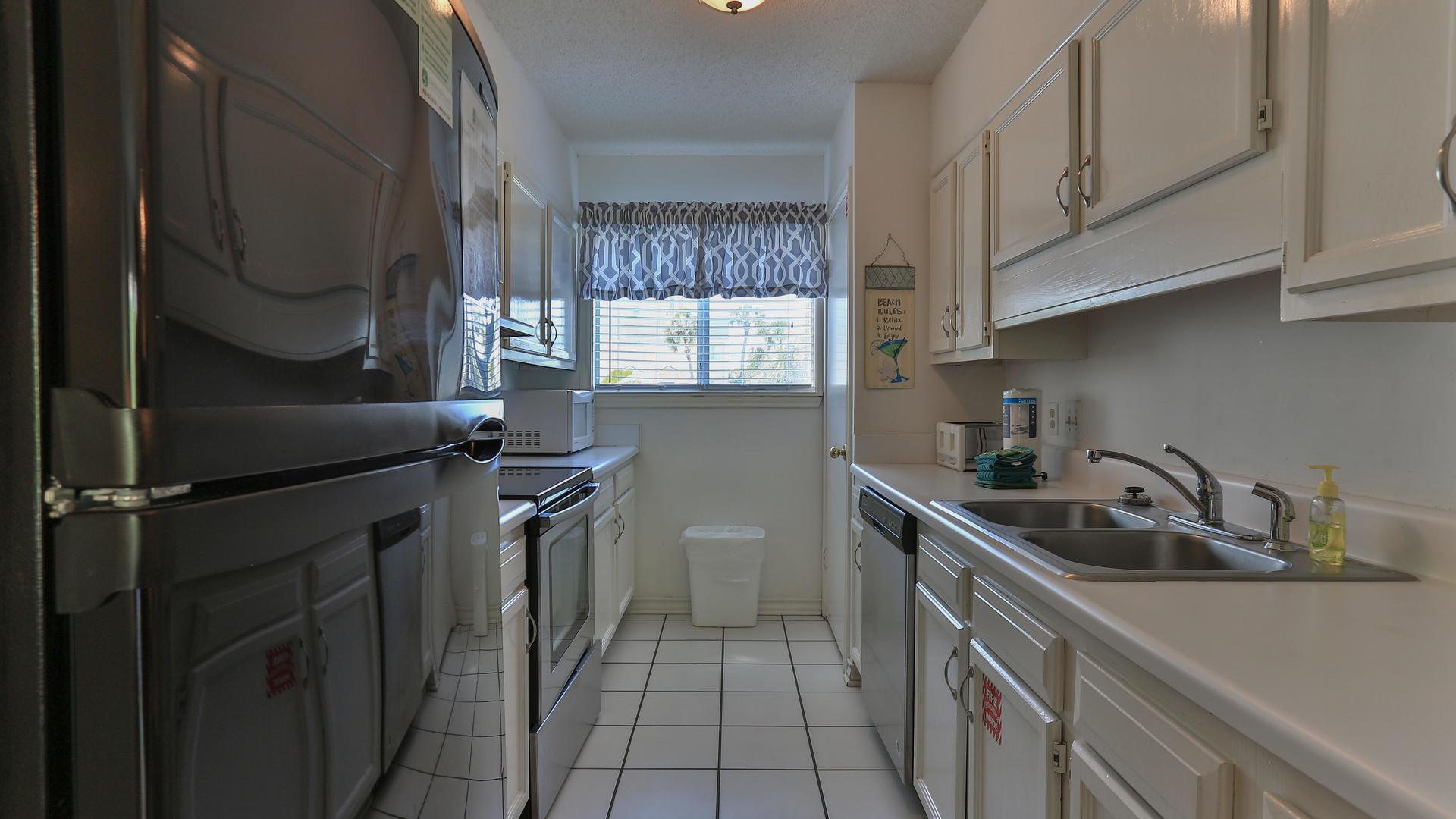940 Highway 98, Unit 102 Destin, FL 32541 - Photo 12 of 18 a kitchen with stainless steel appliances a sink stove and cabinets