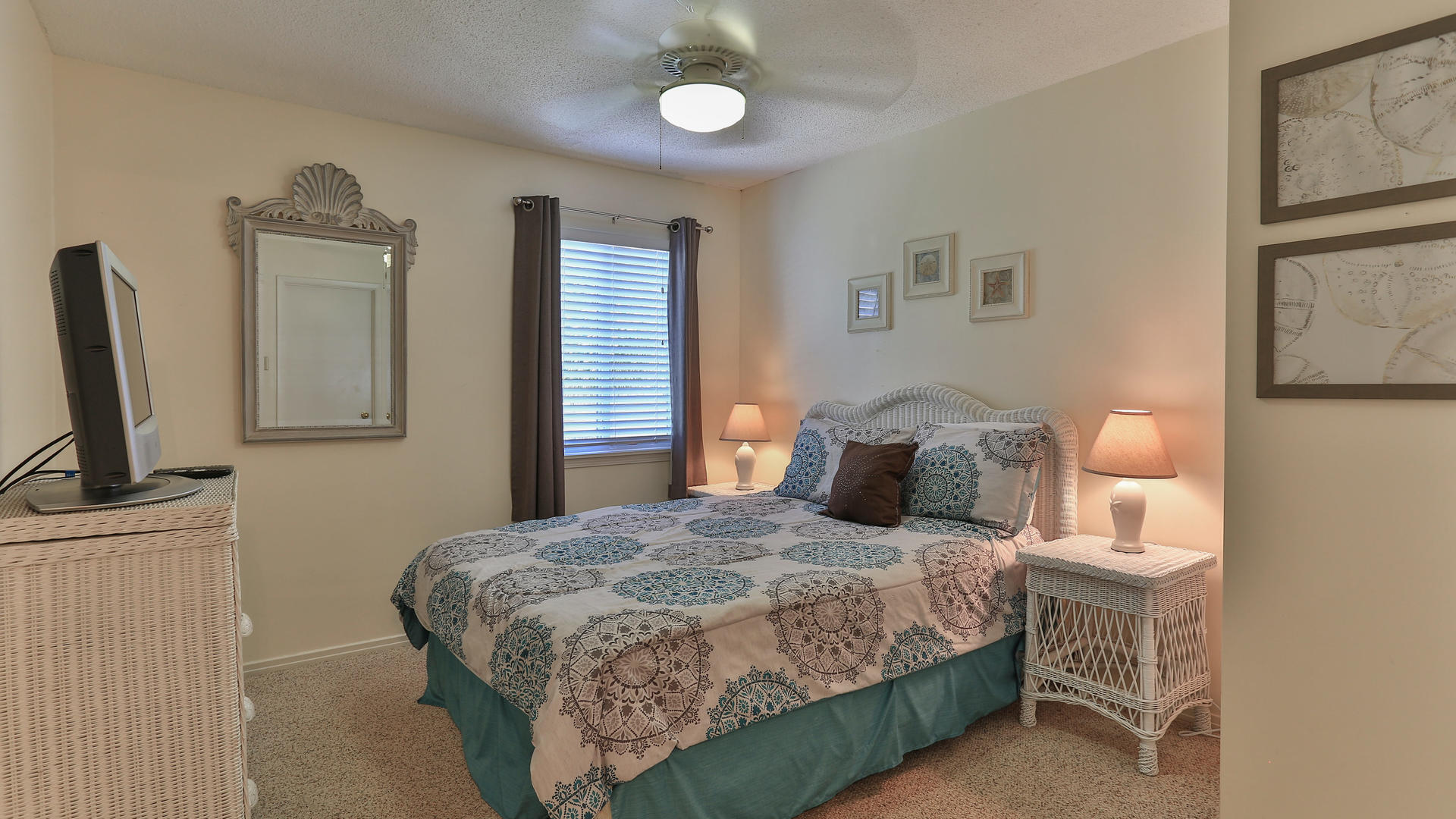940 Highway 98, Unit 102 Destin, FL 32541 - Photo 15 of 18 a bedroom with a bed wooden floor and a flat tv screen