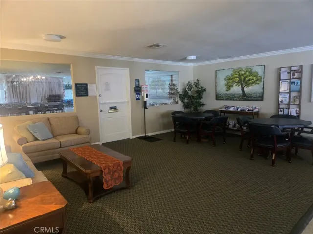a living room with furniture kitchen view and a chandelier
