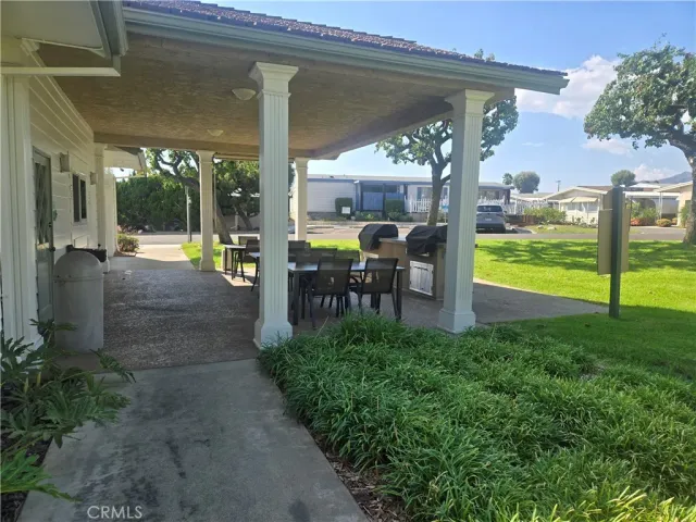 a view of an outside dining space with furniture swimming pool and a yard