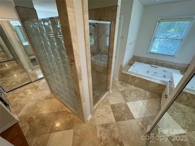 a bathroom with a glass door shower and a mirror