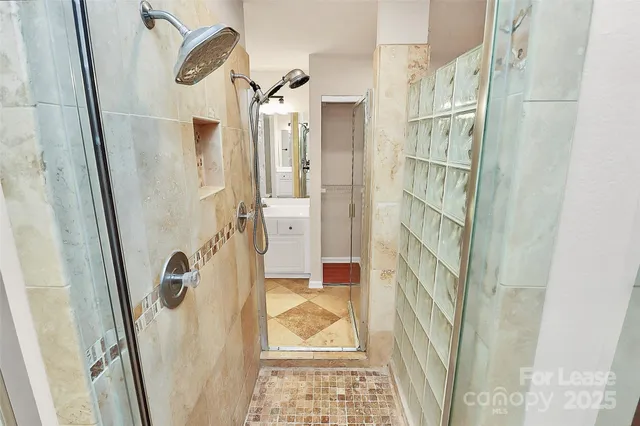 a bathroom with a granite countertop shower and a mirror