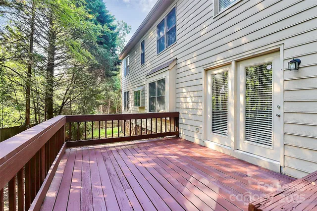 a view of deck with wooden floor and fence and a bench
