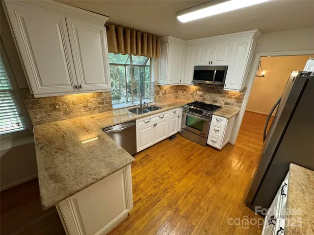 a kitchen with a sink appliances and cabinets