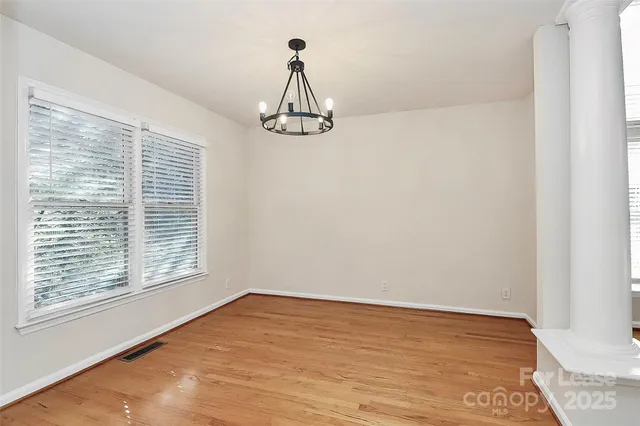 a view of a room with wooden floor and windows