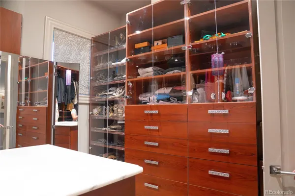 a view of walk in closet with clothes