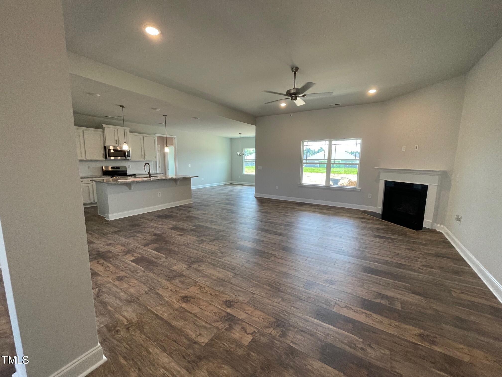 4356 Coolwater Drive Bailey, NC 27807 - Photo 2 of 17 an empty room with wooden floor and kitchen view